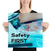 A safety poster showing a close up of a lab worker's eyes examining a sample on a microscope while wearing safety glasses and a mask with the slogan safety first in bold letters.