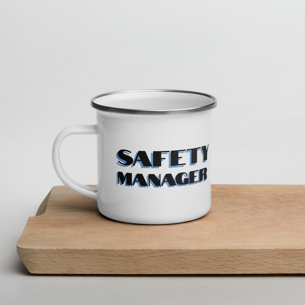 White metal mug with a silver rim with "Safety Manager" in bold text with a blue drop shadow across the side.