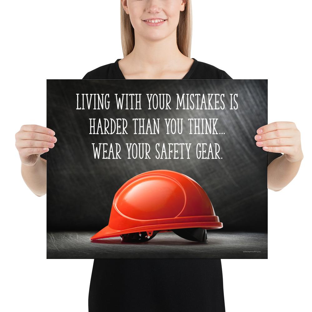A workplace safety poster showing a bright red hard hat with an ominous black background with the slogan living with your mistakes is harder than you think, wear your safety gear.