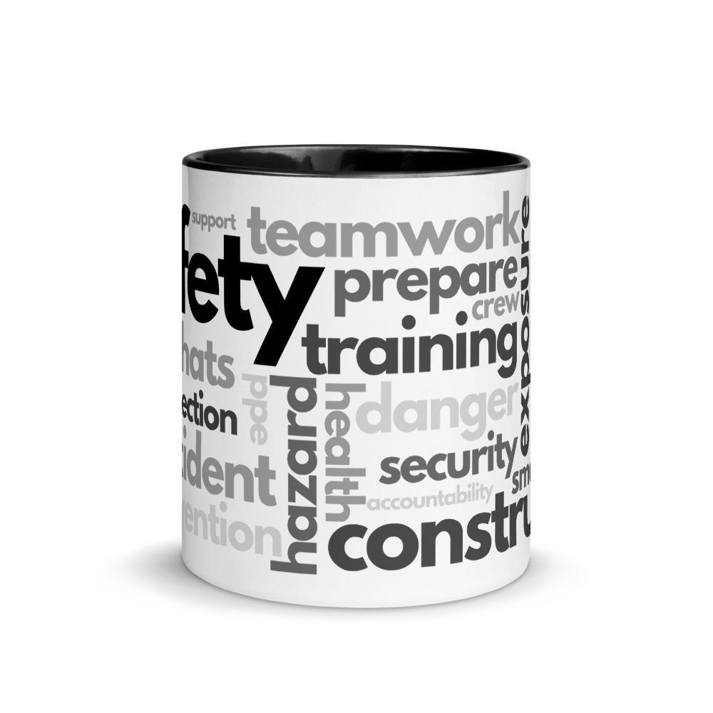 White ceramic mug with safety terms like hard hats, protection, and encourage, in a various shades of black and grey across the mug with a black rim, inside, and handle.