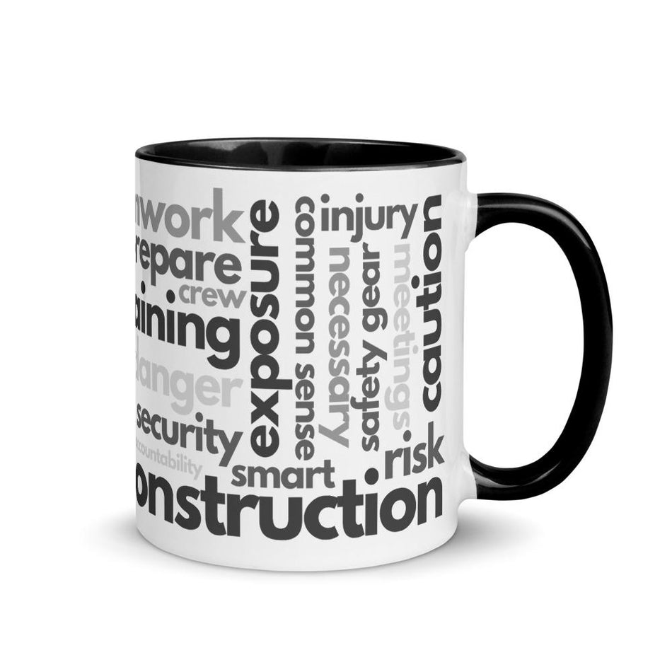 White ceramic mug with safety terms like hard hats, protection, and encourage, in a various shades of black and grey across the mug with a black rim, inside, and handle.