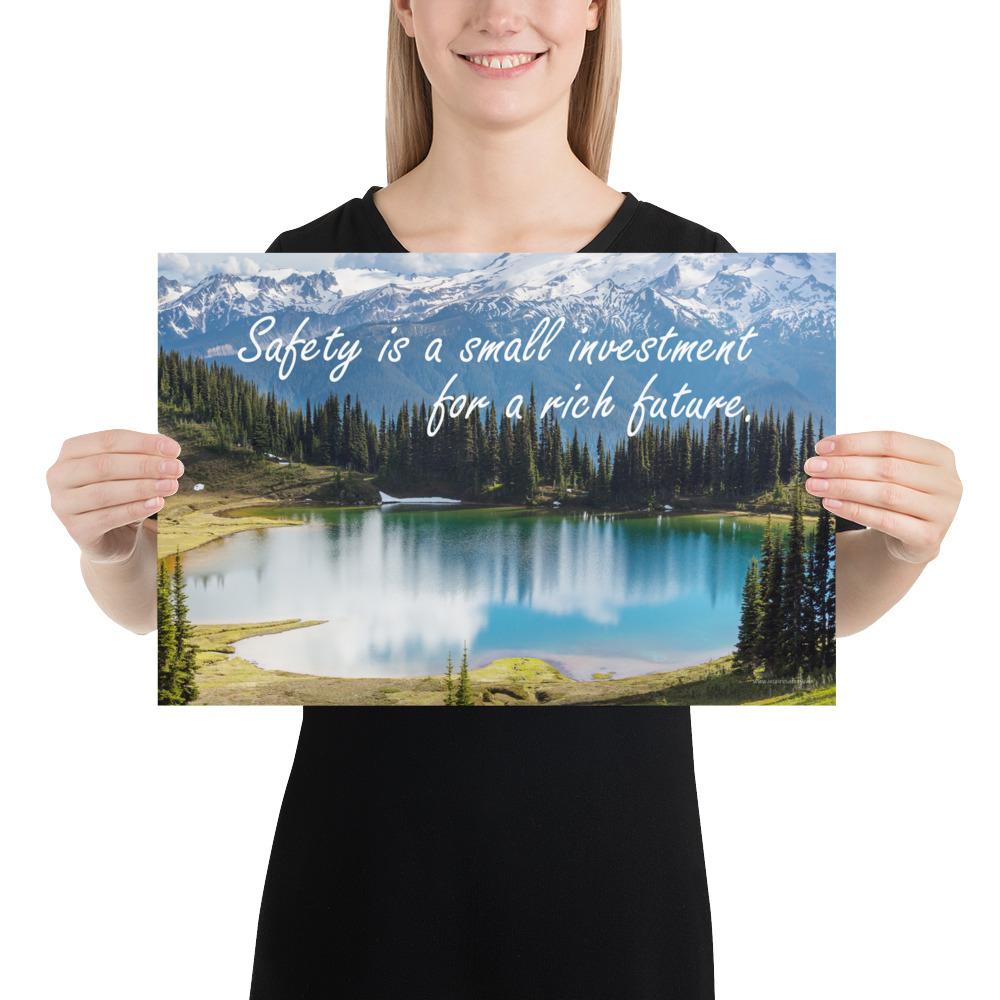A workplace safety poster depicting a beautiful pond in the foreground, lush evergreens in the middle ground and snow-capped mountains in the background with text saying safety is a small investment for a rich future.