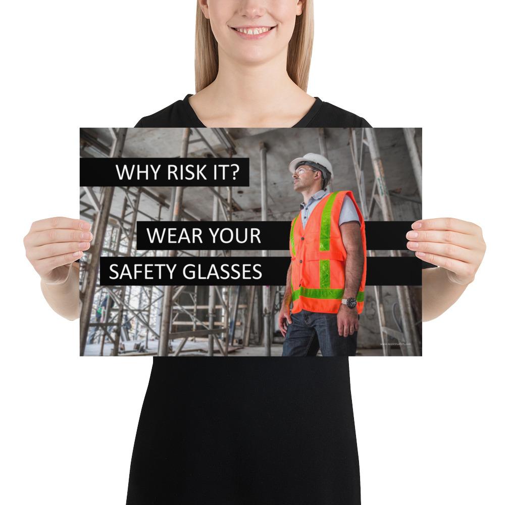 A safety poster showing a construction worker in a reflective orange vest, hard hat, and safety glasses on a construction site looking out with a safety slogan to the left.