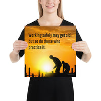 A workplace safety poster showing a construction site and construction workers being silhouetted by a bright and beautiful sunset of different shades of orange with the slogan working safely may get old, but so do those who practice it.