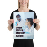 Male and female workers wearing lab coats and safety glasses while inspecting a test tube with a safety slogan written in bold text.