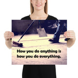Safety poster showing a closeup of the ground where a warehouse or construction worker is sweeping the workshop floor and an encouraging safety slogan written in bold text.