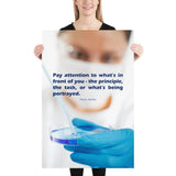 Safety poster showing a close up of a woman's face wearing safety glasses and a white face mask, holding a petri dish and pipette with a safety quote written in blue text.