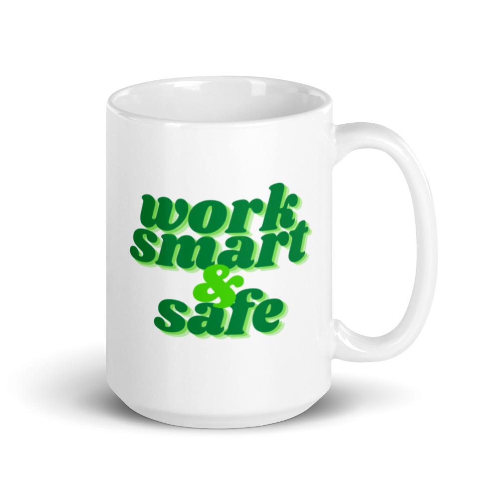 A white ceramic mug with bold green text that says "Work smart and safe."