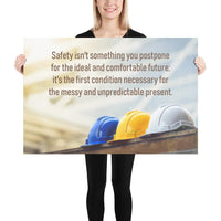 A workplace safety poster showing 3 multi colored hardhats sitting on a wall with the slogan safety isn't something you postpone for the ideal and comfortable future. It's the first condition necessary for the messy and unpredictable present.