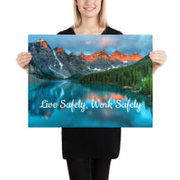 A workplace safety poster depicting a beautiful landscape of mountains with a river flowing down the side of the mountains into a bright blue pond with text saying live safely work safely.