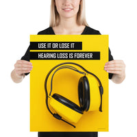 A hearing protection safety poster depicting bright yellow ear muffs on a bright yellow background in the bottom right corner with a bold safety slogan in the upper left corner.