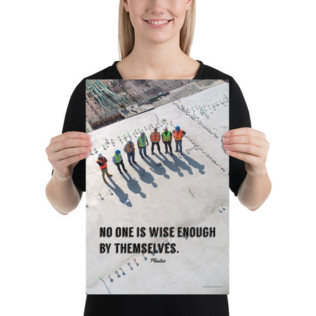 A workplace safety poster showing an aerial view of construction workers in reflective vests standing in a line on top of a building with their shadows being cast on the building with the quote no one is wise enough by themselves by Plautus.