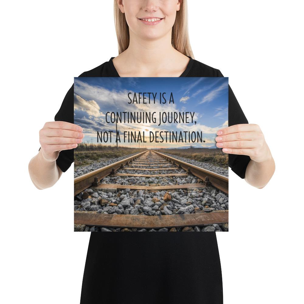 A workplace safety poster depicting old railroad tracks leading into a cloudy horizon with the text safety is a continuing journey, not a final destination.