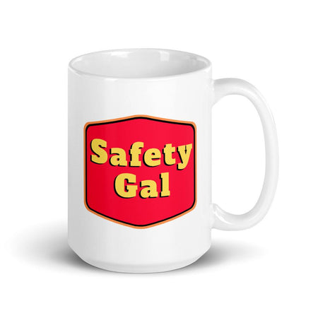 White ceramic mug with a red emblem encasing bold yellow text that says "Safety Gal."