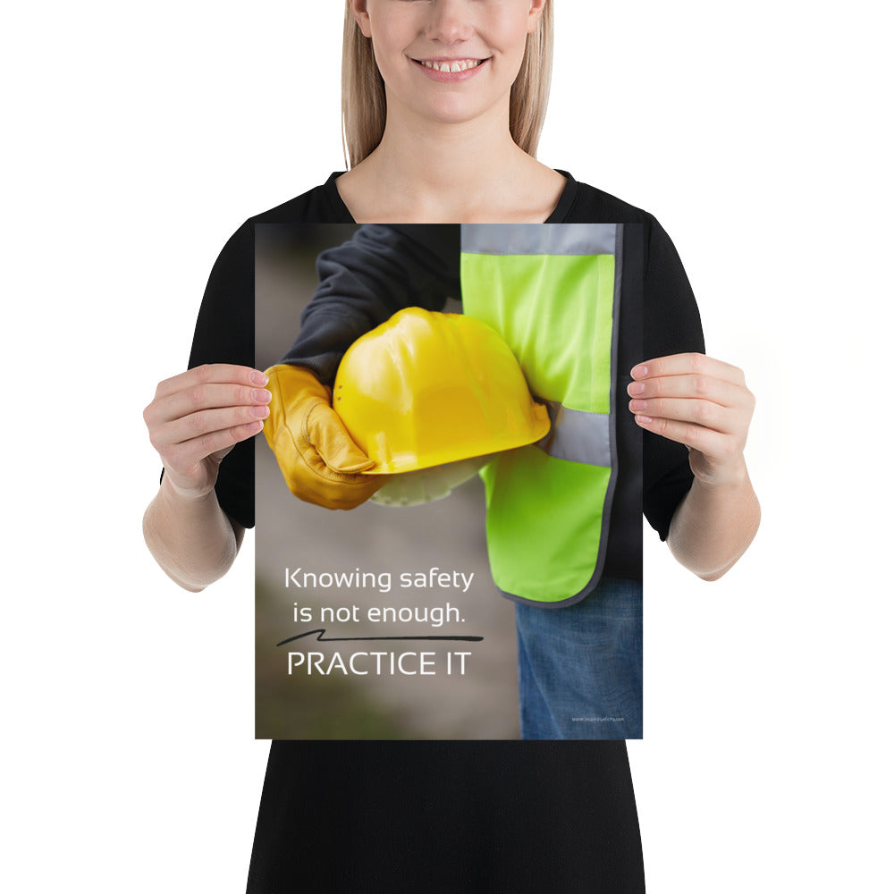A safety poster showing a construction worker in a reflective vest and gloves holding a hard hat with the slogan "Knowing safety is not enough. Practice it."