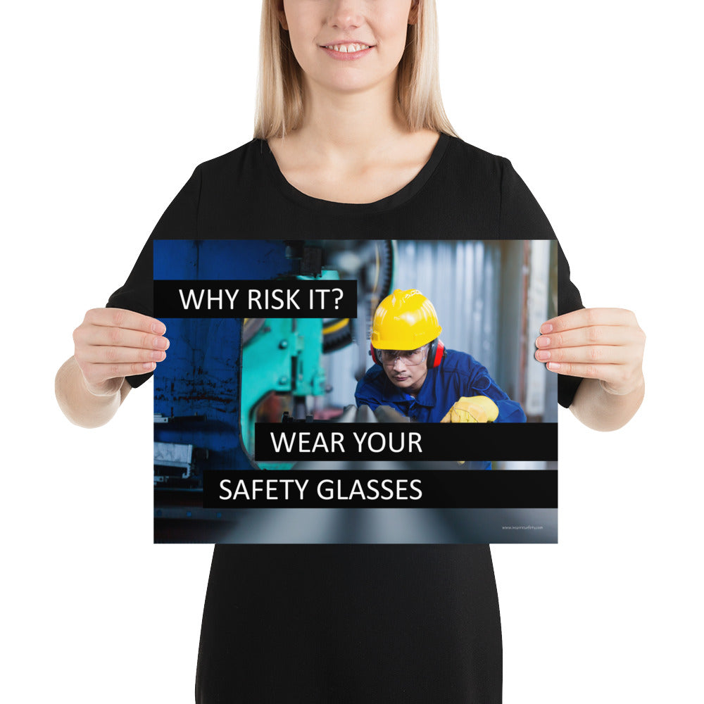 A safety poster showing a worker in a hard hat, ear muffs, safety glasses, and gloves with the slogan "Why Risk It? Wear Your Safety Glasses."