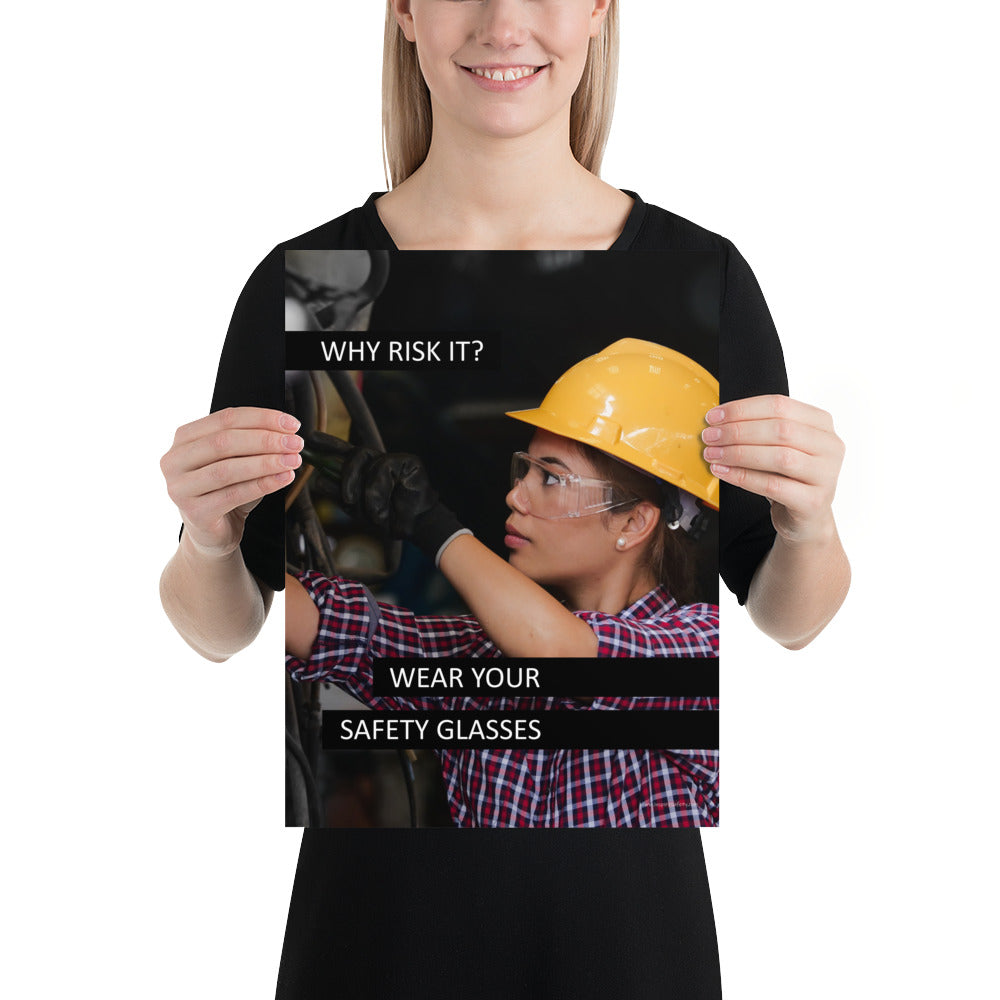 A safety poster showing a female industrial worker donned in safety glasses, a hard hat, and safety gloves with the slogan "Why Risk It? Wear Your Safety Glasses."