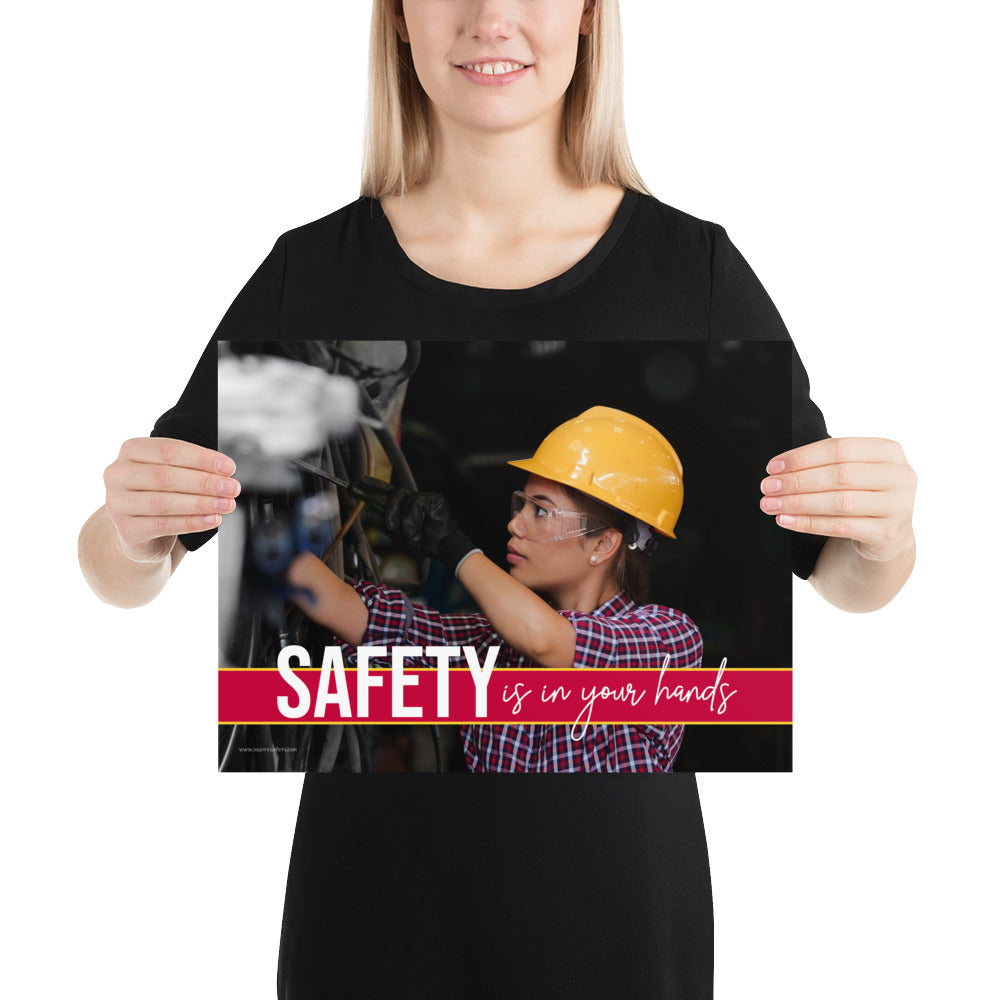 A construction safety poster depicting a woman in a hard hat, gloves, and safety glasses working with the slogan "Safety is in your hands."