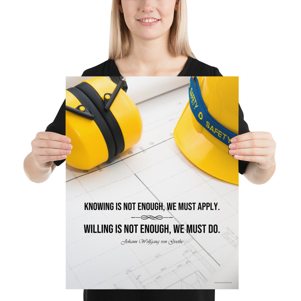 A safety poster showing a yellow hard hat and yellow ear muffs on blueprints with a safety quote by Johann Wolfgang von Goethe that says "Knowing is not enough, we must apply. Willing is not enough, we must do."
