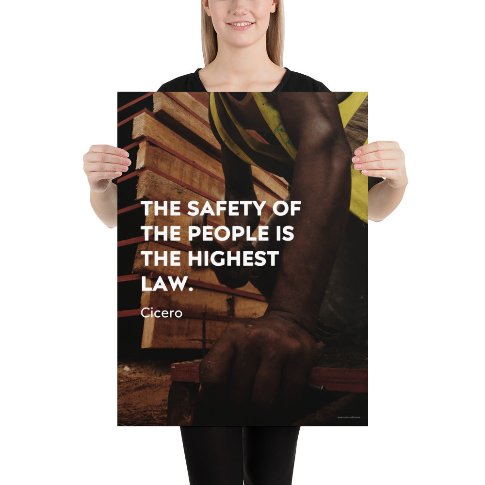 A safety poster of a construction worker in a hi-visibility vest hammering a nail into wood with a safety quote by Cicero that says "The safety of the people is the highest law."