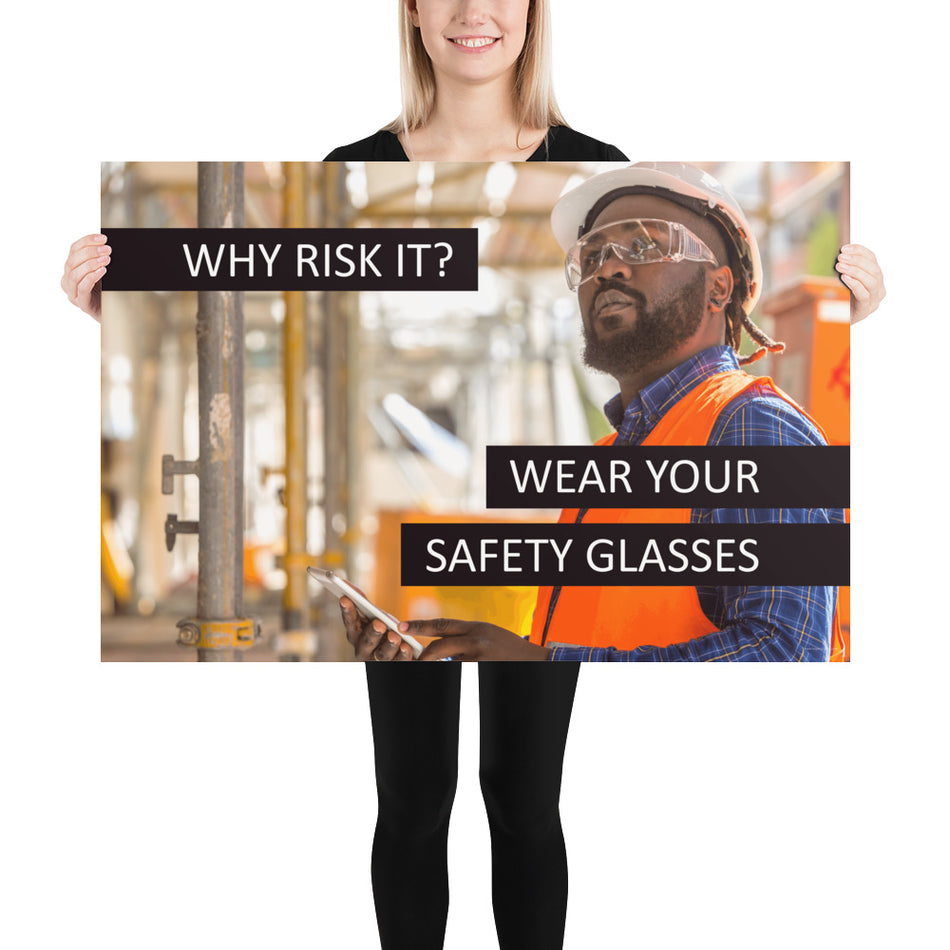 A safety poster showing a man in a reflective vest, hard hat, and safety glasses working with the slogan "Why risk it? Wear your safety glasses."