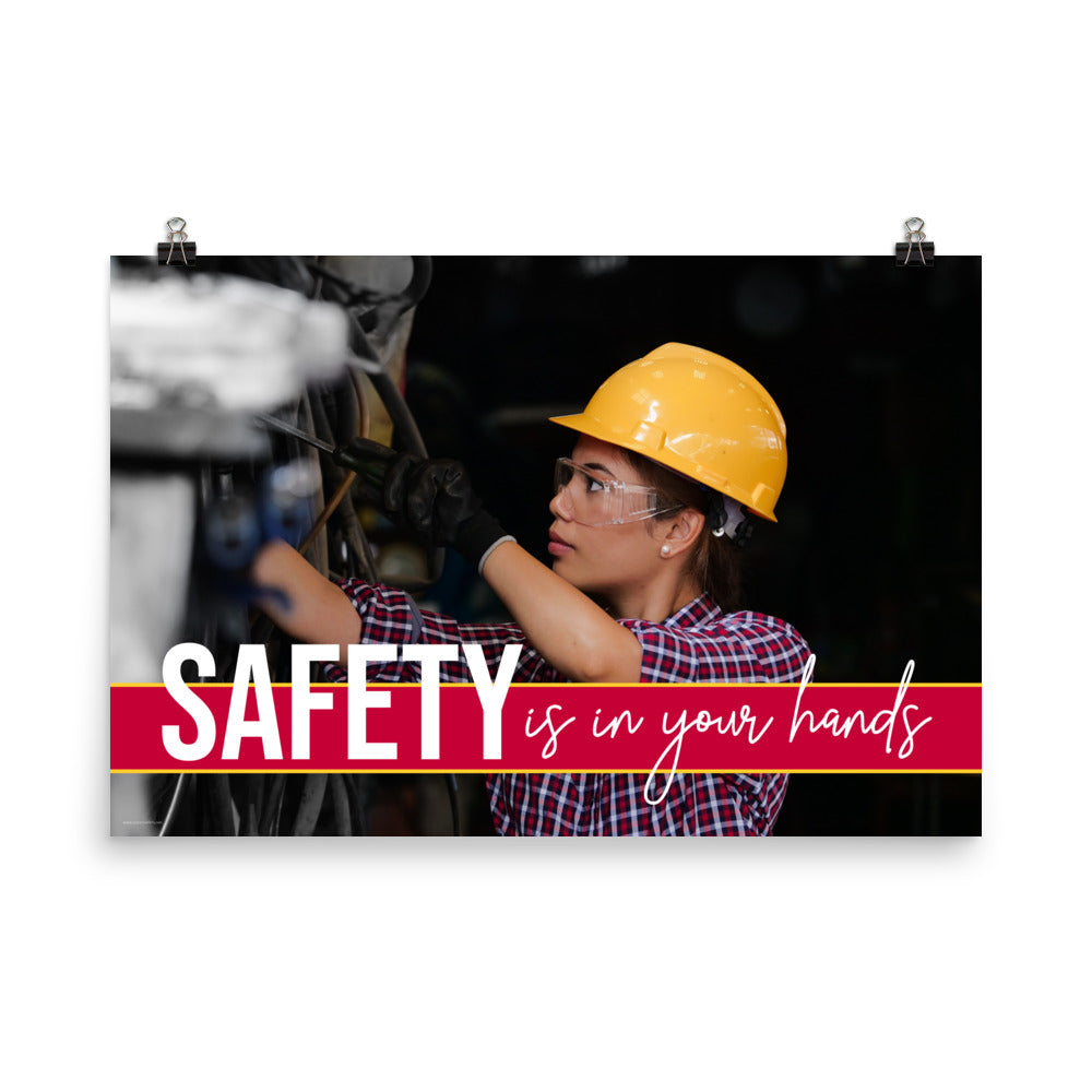 A construction safety poster depicting a woman in a hard hat, gloves, and safety glasses working with the slogan "Safety is in your hands."