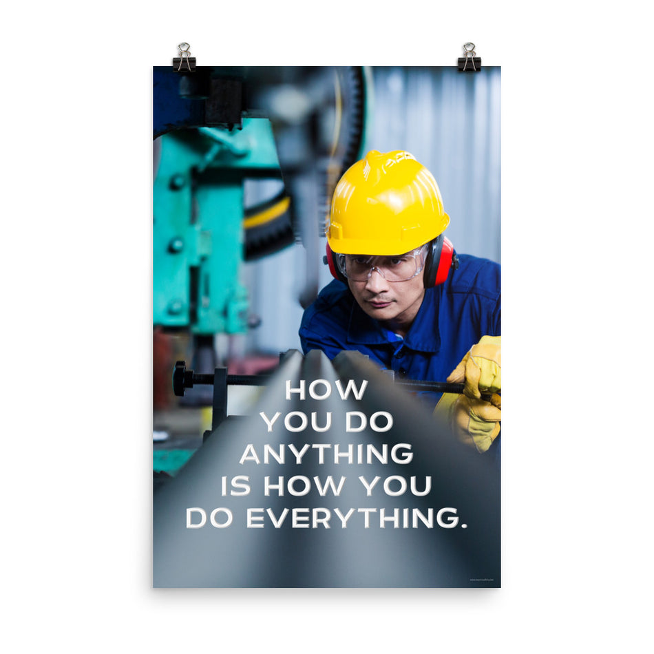 A safety poster showing a man in a yellow hard hat, red earmuffs and safety glasses, working in a factory with the slogan "How you do anything is how you do everything" below him.