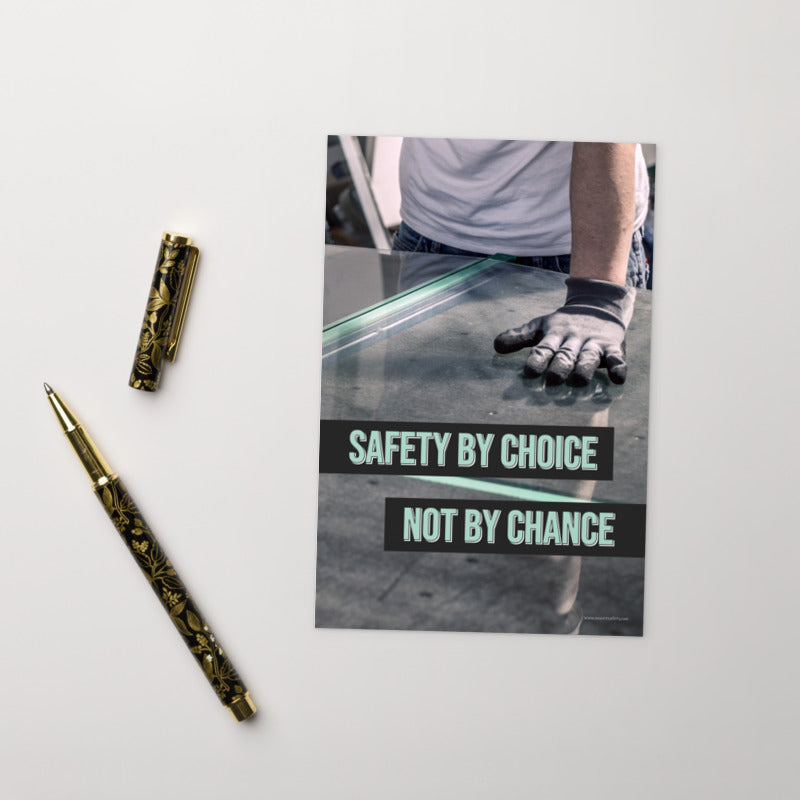 A workplace safety print showing a close-up of a worker's hands grabbing panes of glass with gloves on with the slogan safety by choice not by chance.