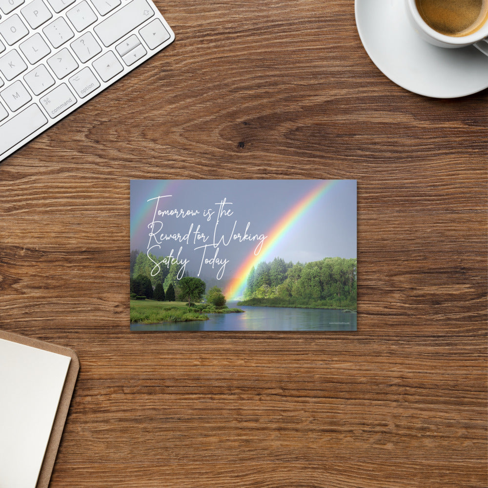 A workplace safety print showing bright forest scene with a lake and vibrant green trees and a colorful rainbow coming out of the forest with the slogan tomorrow is the reward for working safely today.