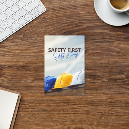 A workplace safety print showing a white, a yellow, and a blue hardhat sitting on a wall with the slogan safety first, safety always.