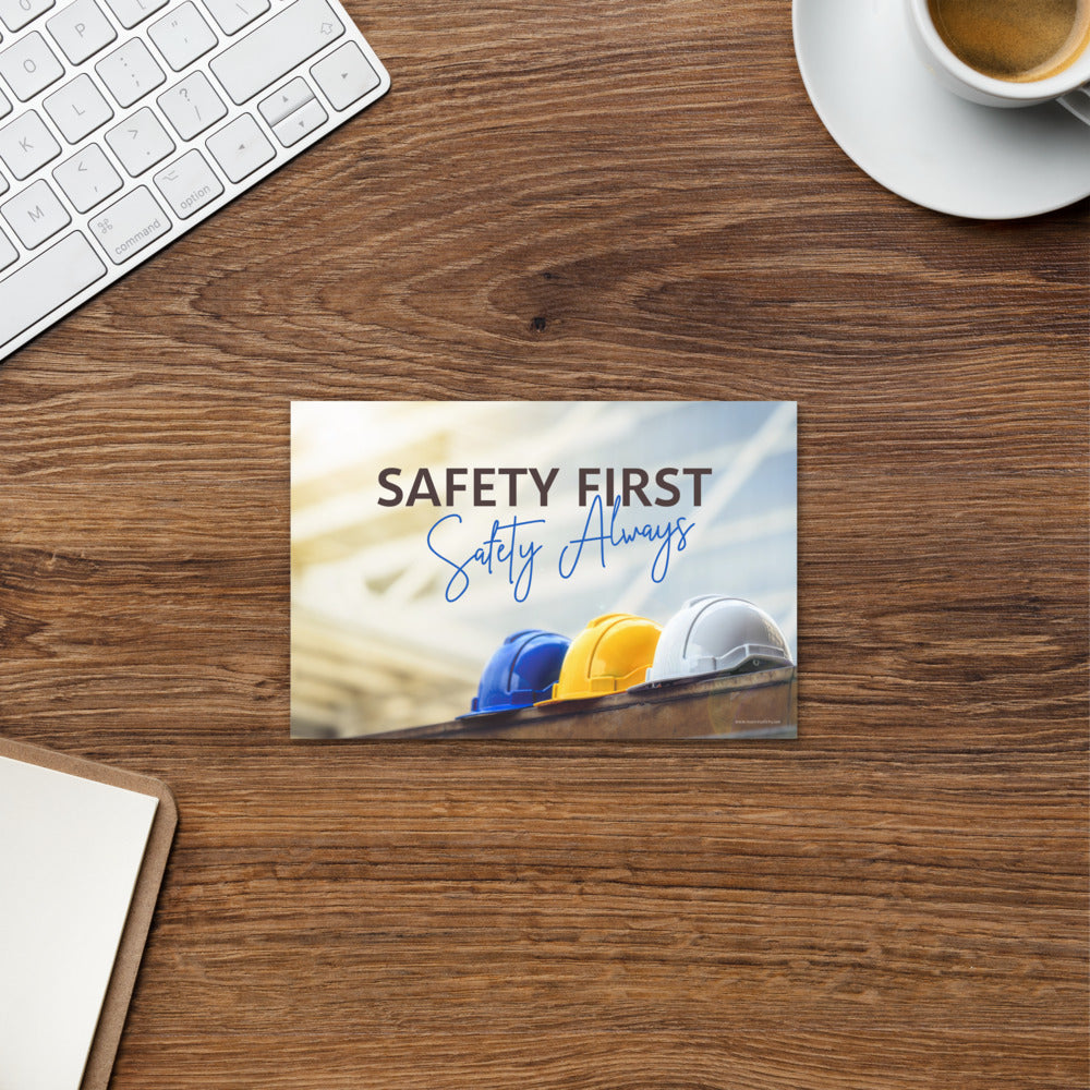 A workplace safety print showing a white, a yellow, and a blue hardhat sitting on a wall with the slogan safety first, safety always.