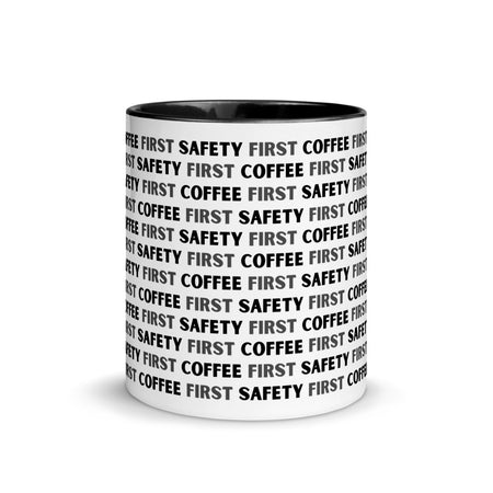 White ceramic mug with black repeating text that says "Safety First, Coffee First" with a black rim, inside, and handle.