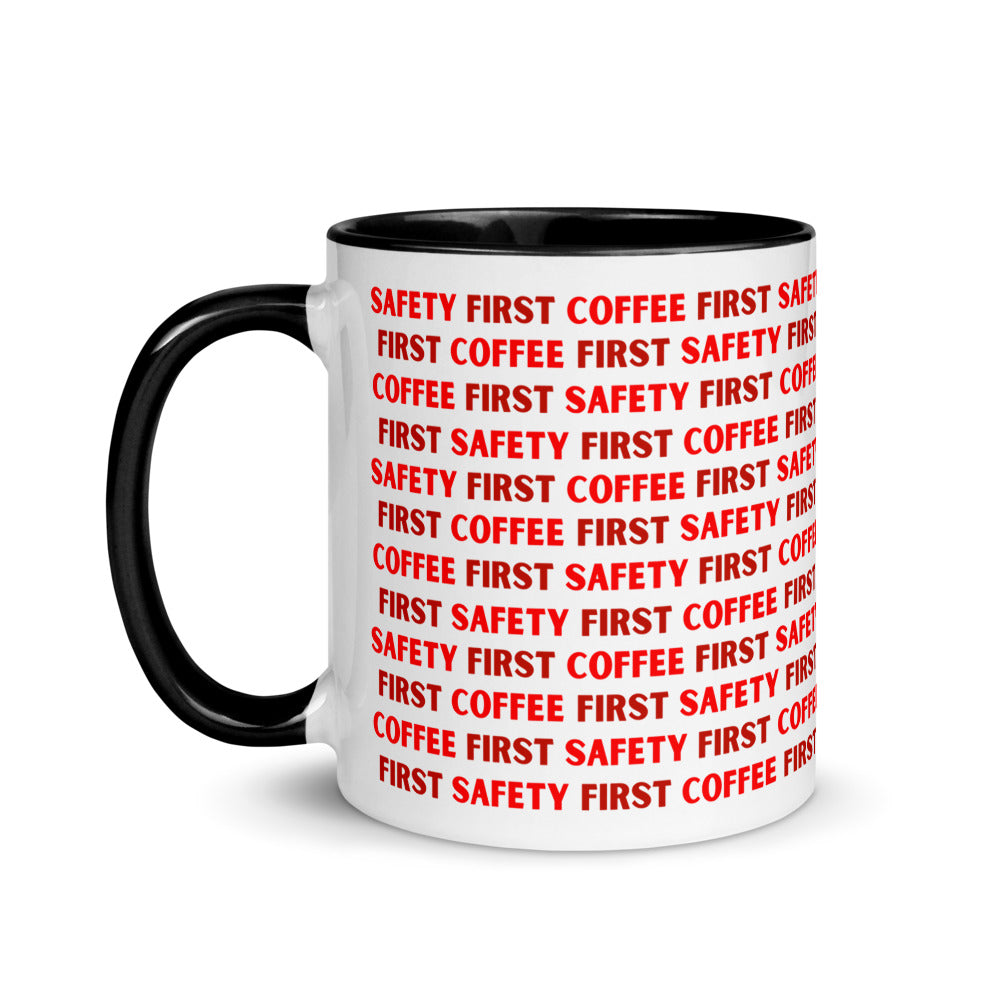 White ceramic mug with red repeating text that says "Safety First, Coffee First" with a black rim, inside, and handle.