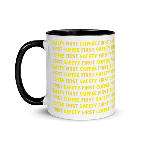 White ceramic mug with yellow repeating text that says "Safety First, Coffee First" with a black rim, inside, and handle.