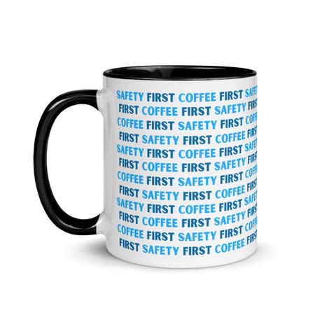 White ceramic mug with blue repeating text that says "Safety First, Coffee First" with a black rim, inside, and handle.