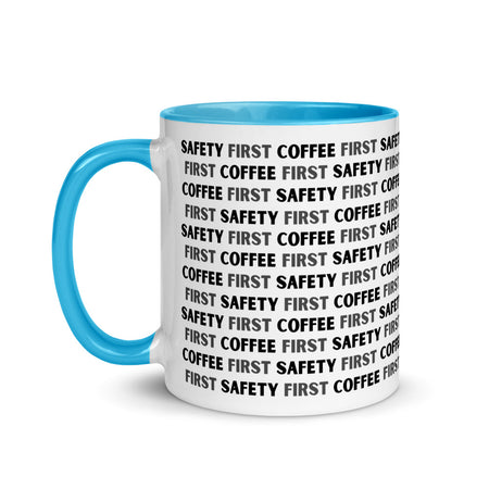 White ceramic mug with black repeating text that says "Safety First, Coffee First" with a blue rim, inside, and handle.