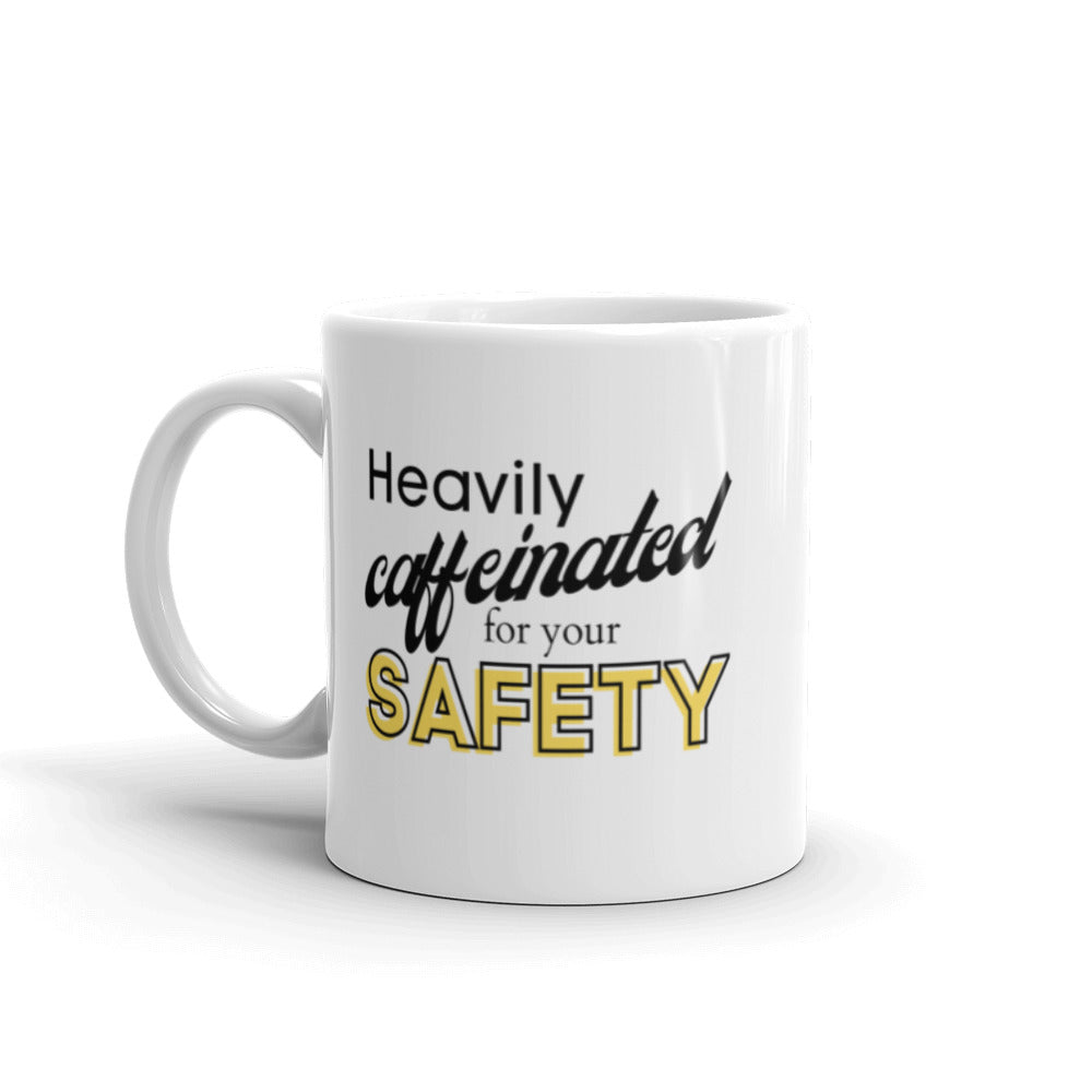 White ceramic mug with the phrase "Heavily caffeinated for your safety."